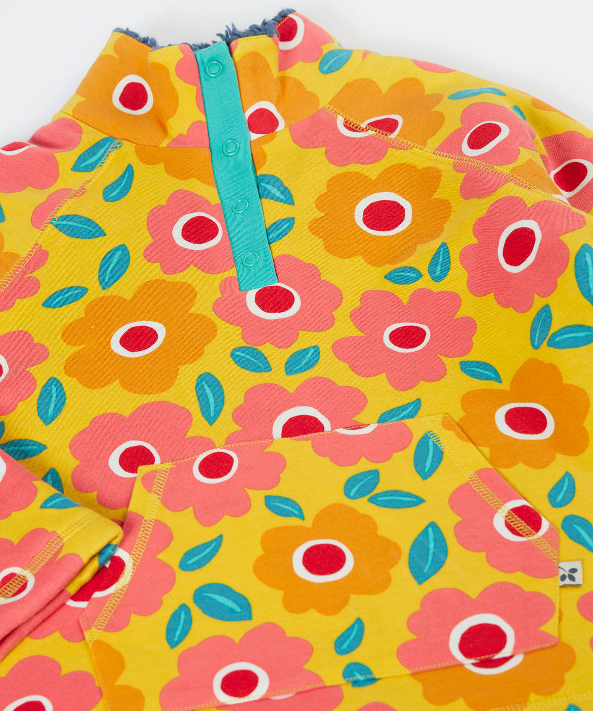A close up of the yellow Frugi organic cotton fleece laid flat showing the repeating floral print and pouch pocket