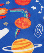 A closer look at the yellow, and orange applique planets, which also has space style embroidery details on a blue fabric
