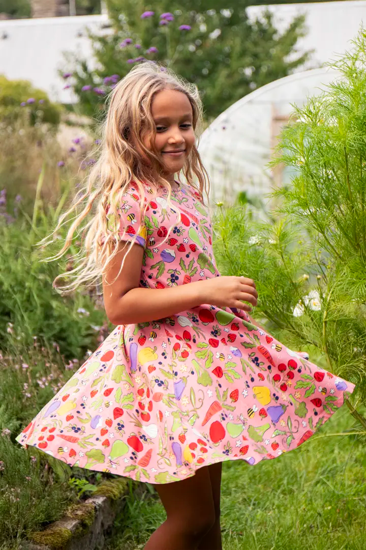 Frugi Spring Skater Dress in Grow Happiness pink vegetable print on child, to represent new Frugi Spring Summer at Babipur.