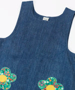 Frugi organic cotton mid wash denim kids pinafore dress laid flat showing a close up of a the shoulder straps and scoop neck line 