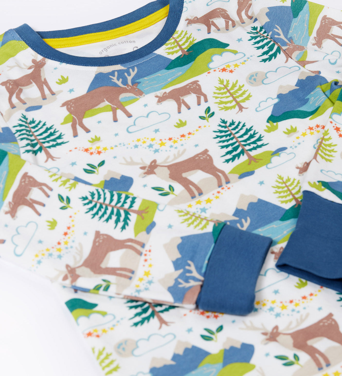 A close up of the Frugi sundown pyjamas top in reindeer fields design available at Babipur showing the mountainscape print and blue trim detail on the neck