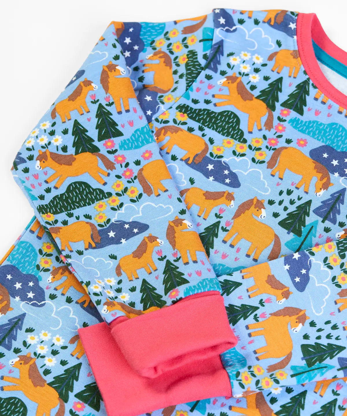 Frugi GOTS 100% organic cotton kids pyjama top in light blue with a repeating shetland pony print and a pink cuff and neck line 