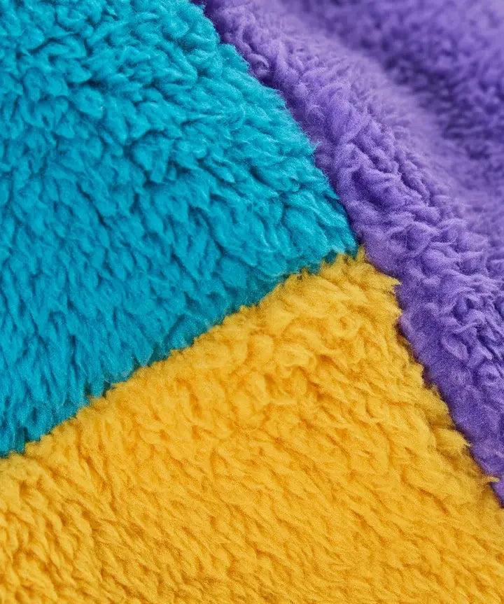 Frugi ted fleece trapper hat, close up of soft, recycled polyester fleece in yellow, blue and purple colourblock.