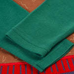 A closer look at the green sleeves on the Frugi Terrific Applique Top - Teal/Fairisle Bear. The bear applique is partially shown behind the folded sleeves