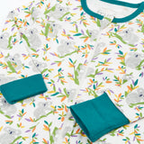 Frugi GOTS 100% organic cotton onesie in white with repeating koala printslaid flat showing the teal cuffs and neck trim dressing