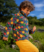 Frugi zipped ted fleece in navy with orange star print worn by child outside with yellow cord trousers.