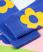 A closer look at the ribbed, knitted cuffs on the Frugi Zola Reversible Knitted Dress - Blue Tang/Retro Floral. The image shows royal blue sleeves with bold, yellow floral prints