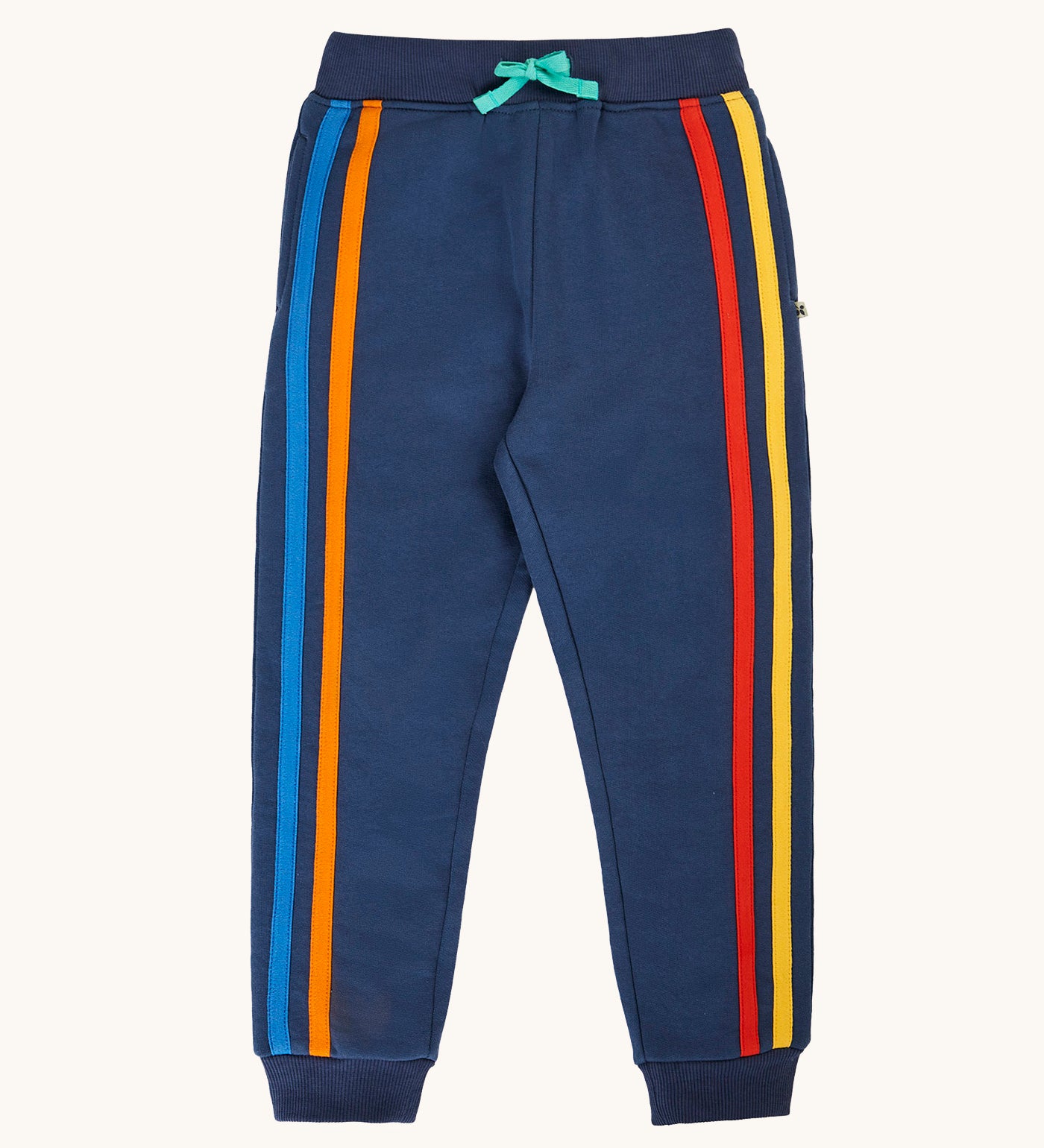 Frugi organic cotton joggers laid flat. In navy with a orange and light blue stripe on one leg with a red and yellow stripe on the other leg.
