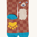 A close up of the Frugi bear character sock from the beary wild pack. A brown GOTS organic cotton sock with blue trim and a yellow paw on the sole.