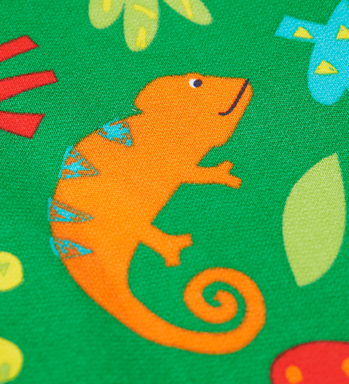 A close up of the orange chameleon design against the bright green Frugi snuggle suit.