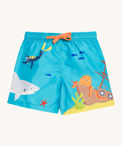 Frugi blue swim shorts deep dea diver design on a cream background.