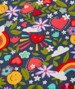 A close up of a smiling heart surrounded by repeating rainbow, sun and flower prints on the navy frugi t-shirt