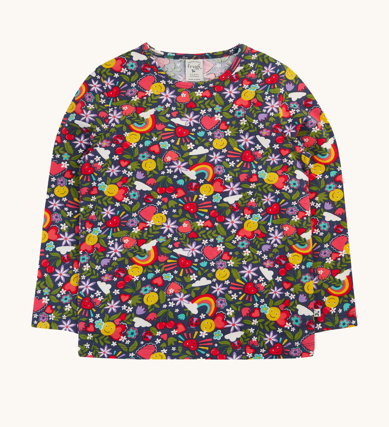 Frugi organic cotton long sleeve top laid flat. In navy with a repeating rainbow, flowers and sun print