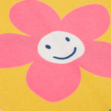 A close up of the  Frugi kids luana bumblebee/flower leggings showing the pink flower print detail on yellow organic cotton fabric.