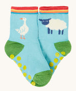 Frugi organic sock laid flat. In light blue with a white goose on one sock and a white sheep on the other.