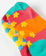A close up of the underside of the Frugi organic cotton 2 pack socks laid flat. In bright striped colours with little star grip panels