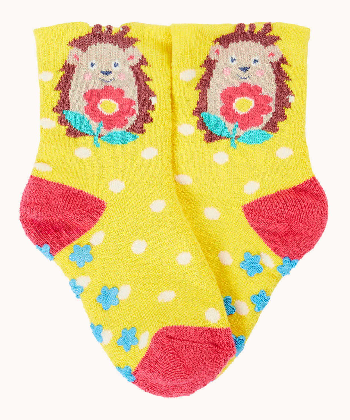 Frugi organic sock laid flat. In yellow with white spots and a hedgehog design on the ankle.