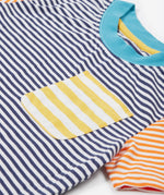 Close up of theFrugi kids hopscotch stripe pocket t-shirt showing the front pocket detail and light blue neck trim on striped organic cotton fabric