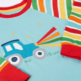A close up of the light blue Frugi pyjama top laid flat showing the tractor design on the front and striped sleeves. 