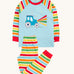 Frugi organic cotton pyjama set laid flat. A light blue top with striped sleeves and a tractor design on the front and matching striped trousers