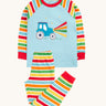 Frugi organic cotton pyjama set laid flat. A light blue top with striped sleeves and a tractor design on the front and matching striped trousers