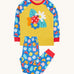 Frugi organic cotton pyjama set laid flat. A mustard yellow top with a ladybird design on the front and blue sleeves with a repeating ladybird design. Trousers in the same blue and the repeating ladybird print