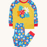 Frugi organic cotton pyjama set laid flat. A mustard yellow top with a ladybird design on the front and blue sleeves with a repeating ladybird design. Trousers in the same blue and the repeating ladybird print