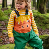 Small child wearing the Frugi water proof holly green/cow character puddle buster in the forest