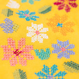 A close up of the Frugi kids carbis hoodie in bumblebee/flowers showing the the embroidery detail on yellow organic cotton fabric. 