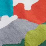 A close up of the Frugi kid reva knitted cardigan in blue/mountain scene showing the mountain scene colour detail on organic cotton fabric.