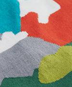 A close up of the Frugi kid reva knitted cardigan in blue/mountain scene showing the mountain scene colour detail on organic cotton fabric.