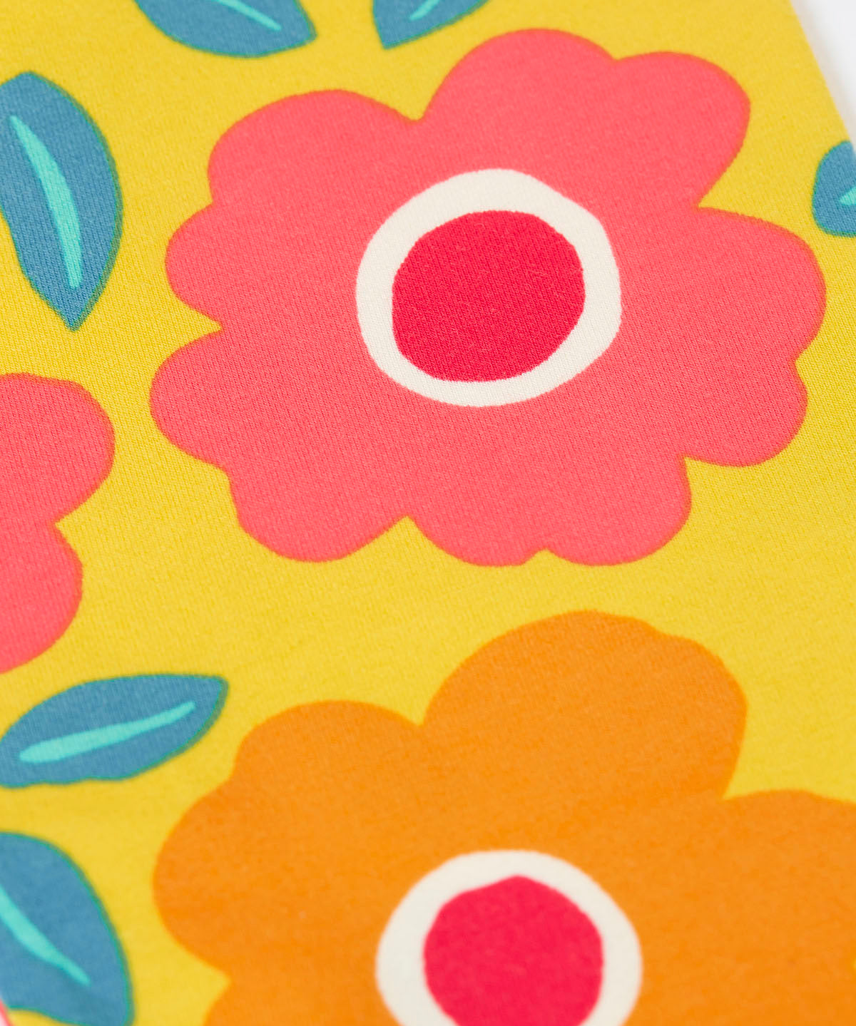 A close up of the repeating floral print on the yellow Frugi leggings