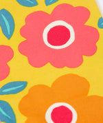 A close up of the repeating floral print on the yellow Frugi leggings