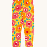 Frugi organic cotton leggings laid flat. In bright yellow with a repeating floral print