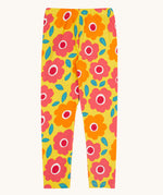 Frugi organic cotton leggings laid flat. In bright yellow with a repeating floral print