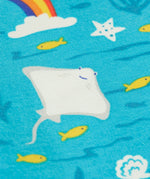 A close up of the repeating grey manta ray and rainbow print on the blue Frugi leggings