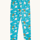 Frugi organic cotton leggings laid flat. In light blue with a repeating grey manta ray and rainbow print.