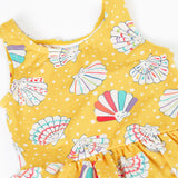 A close up of the Frugi yellow swim suit laid flat showing the repeating white shell design. 