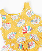 A close up of the Frugi yellow swim suit laid flat showing the repeating white shell design. 