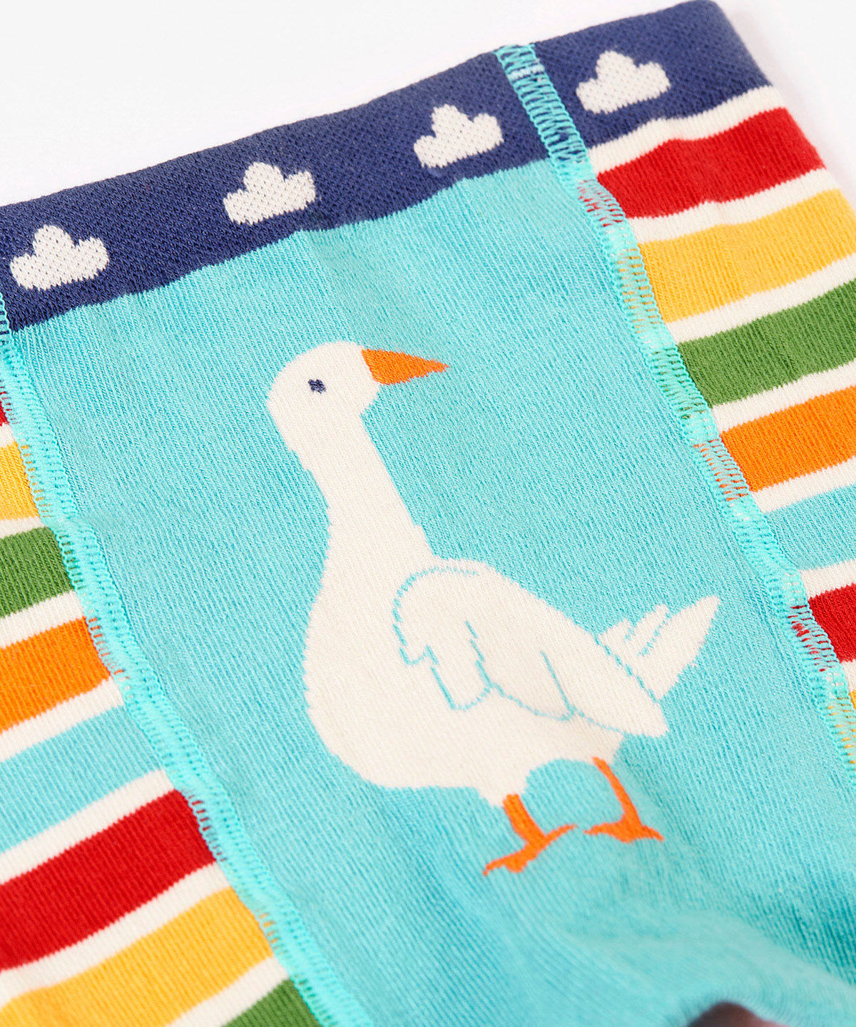 A close up of the multicoloured stripe Frugi organic cotton knitted leggings laid flat. With the white goose design on the front.