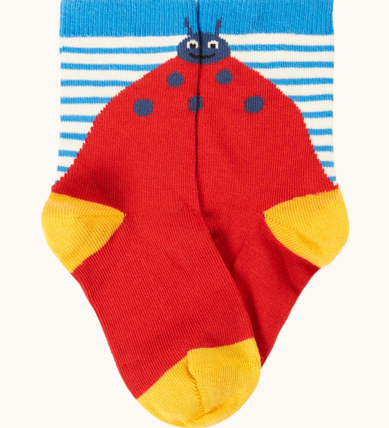 Frugi organic cotton socks laid flat. In a striped design with a playful red ladybird.
