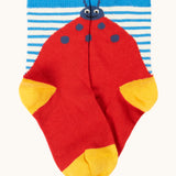 Frugi organic cotton socks laid flat. In a striped design with a playful red ladybird.