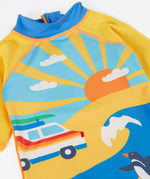 A close up of the Frugi recycled plastic sun safe swimwear all in one suit laid flat the showing sunny ocean theme design featuring a retro camper van 