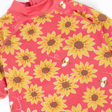 A close up of the pink Frugi all in one sun safe swimwear suit. Showing repeating yellow sunflower and flying bee print.