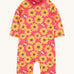 Frugi all in one sun safe swimwear suit. In pink with a repeating yellow sunflower and flying bee print