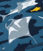 A close up of the repeating grey manta ray print on dark blue fabric 