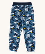 Frugi organic cotton joggers laid flat . In dark blue and navy trim with a repeating grey manta ray and shark print. 