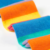 A close up of the bottom half of the light purple Frugi organic cotton tights laid flat showing the striped rainbow design.