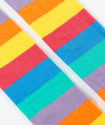 A close up of the rainbow stripe design on the bottom half of the light purple Frugi leggings.