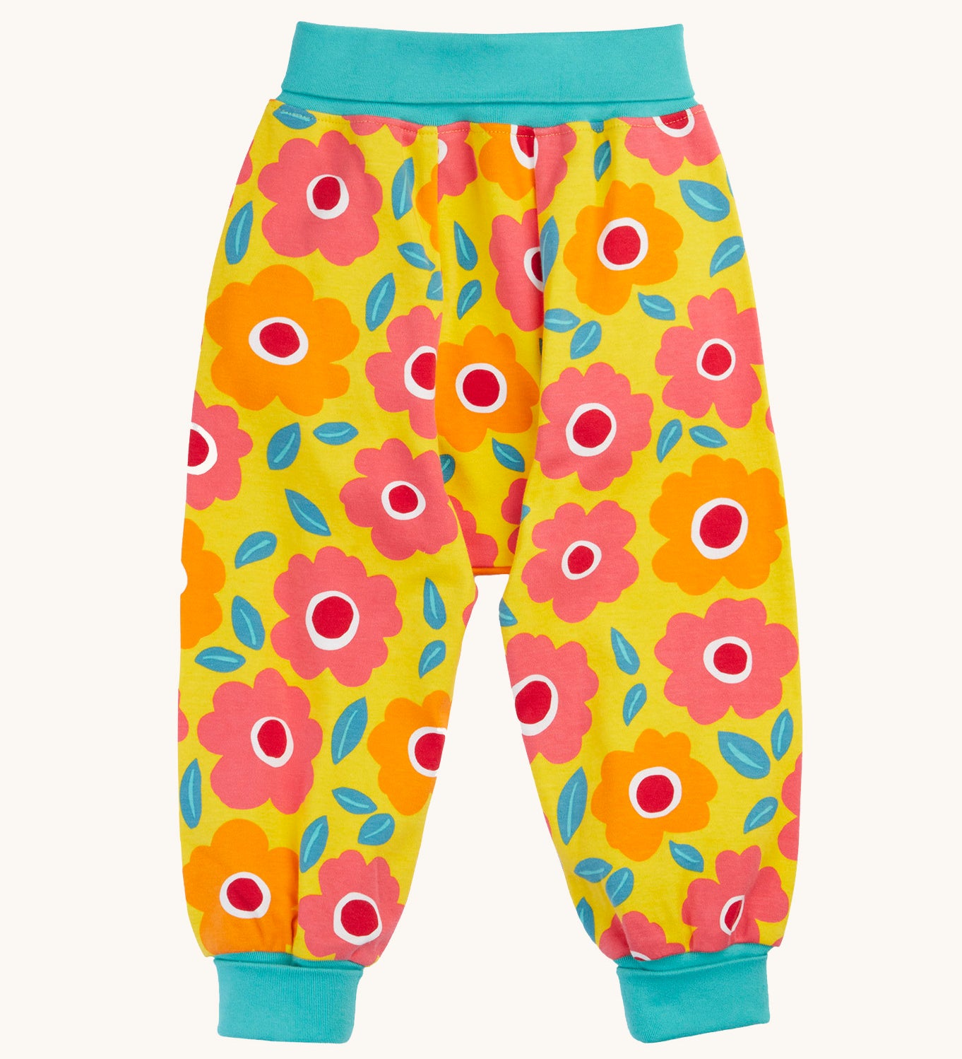 Frugi organic cotton parsnip pants laid flat. In bright yellow with a turquoise waist band and leg cuffs. Has a repeating floral print. 